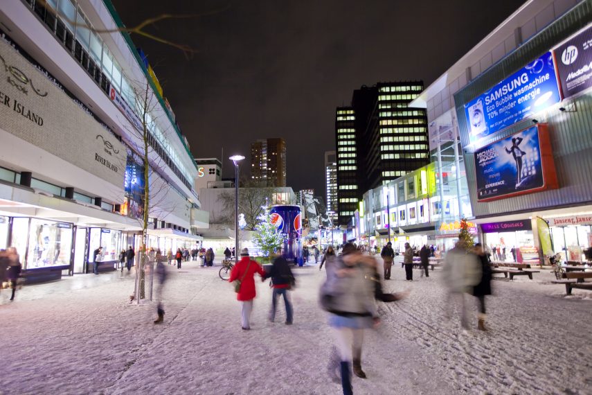 People shopping on the Binnenwegplein on a winter evening.