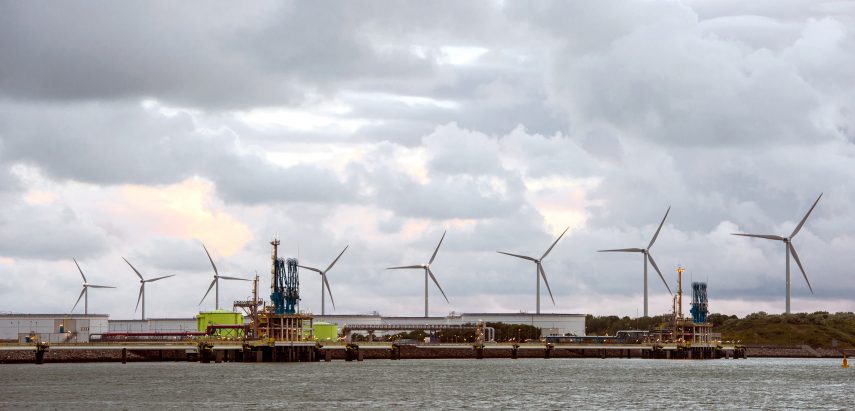 De twee losstations van de Gate LNG Terminal op de Maasvlakte met windmolens in de achtergrond.