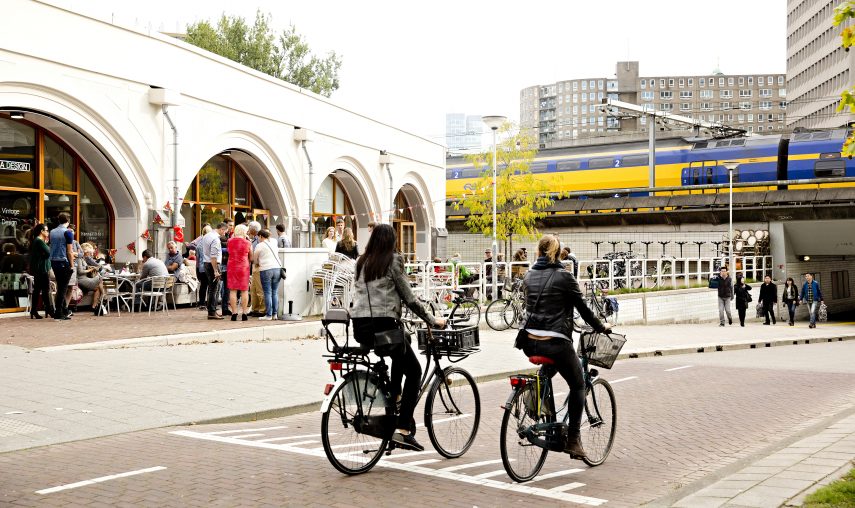 People cycling past the Hofbogen, the former Hofplein station.