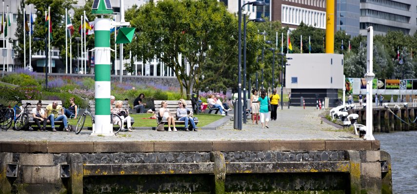 People relaxing at the waterfront at Leuvehoofd, close to the Erasmusbridge