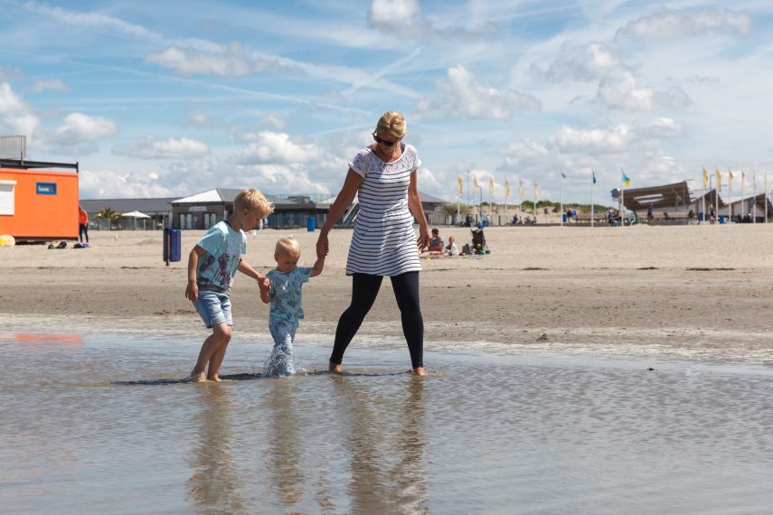 Mother and children at Hoek van Holland (Hook of Holland) beach. The boulevard is visible in the background.