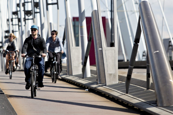 Cyclists crossing the Erasmusbridge designed by Ben van Berkel.