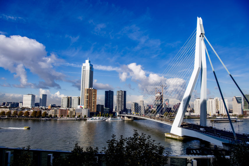 Zicht vanaf het nhow Rotterdam hotel op de Erasmusbrug met De Zalmhaven en de skyline van Rotterdam.