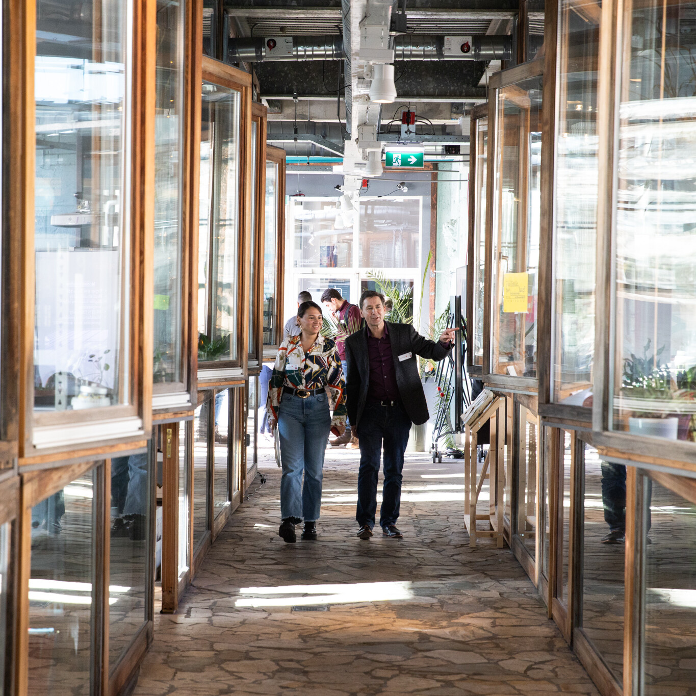 Mensen lopen door BlueCity. Symmetrische foto van glazen gang.