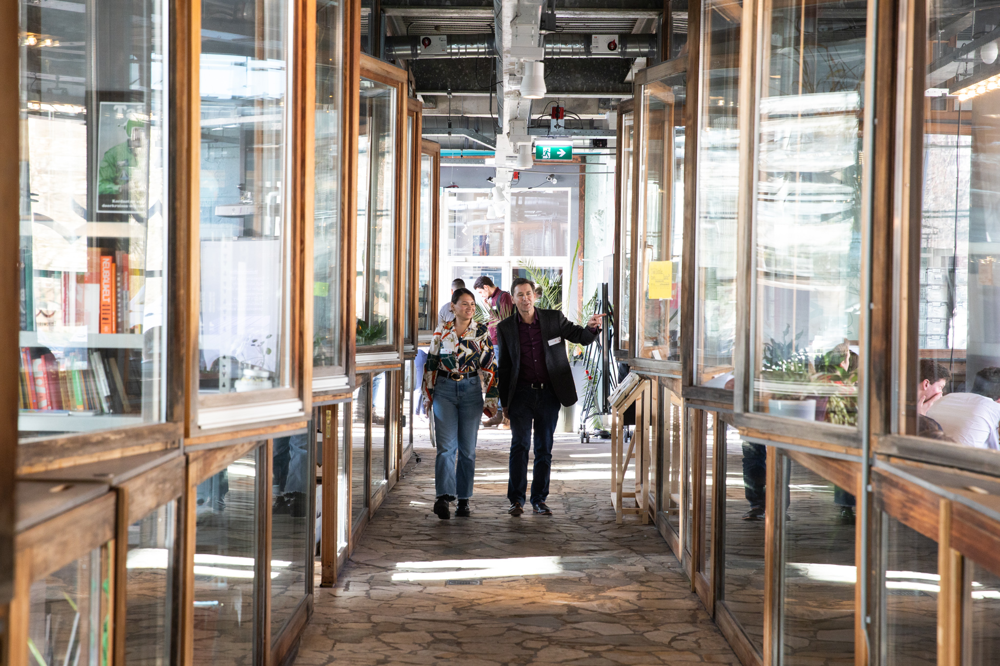 Mensen lopen door BlueCity. Symmetrische foto van glazen gang.