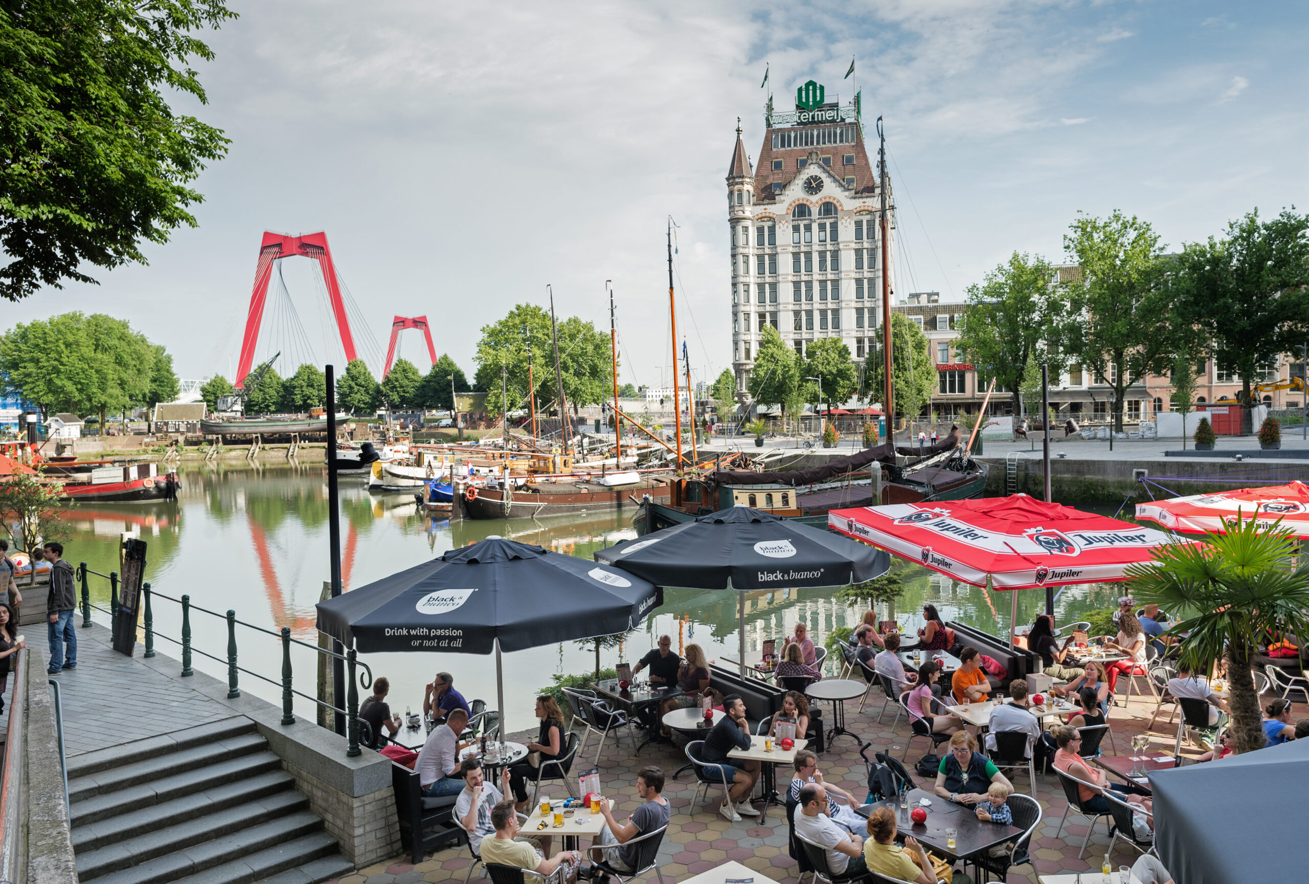 Terras aan de Oude Haven, de oudste haven in het centrum van Rotterdam. Nu is het vooral een uitgaansgebied. Op de achtergrond Het Witte Huis, bij zijn oplevering in 1898 het hoogste kantoorgebouw van Europa. Linksachter de rode Willemsbrug.