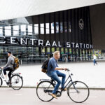 Fietsers rijden voorbij Rotterdam Centraal