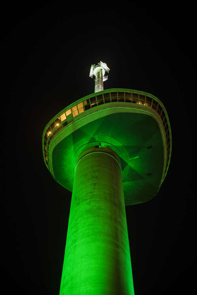 Euromast groen verlicht in de avond. 