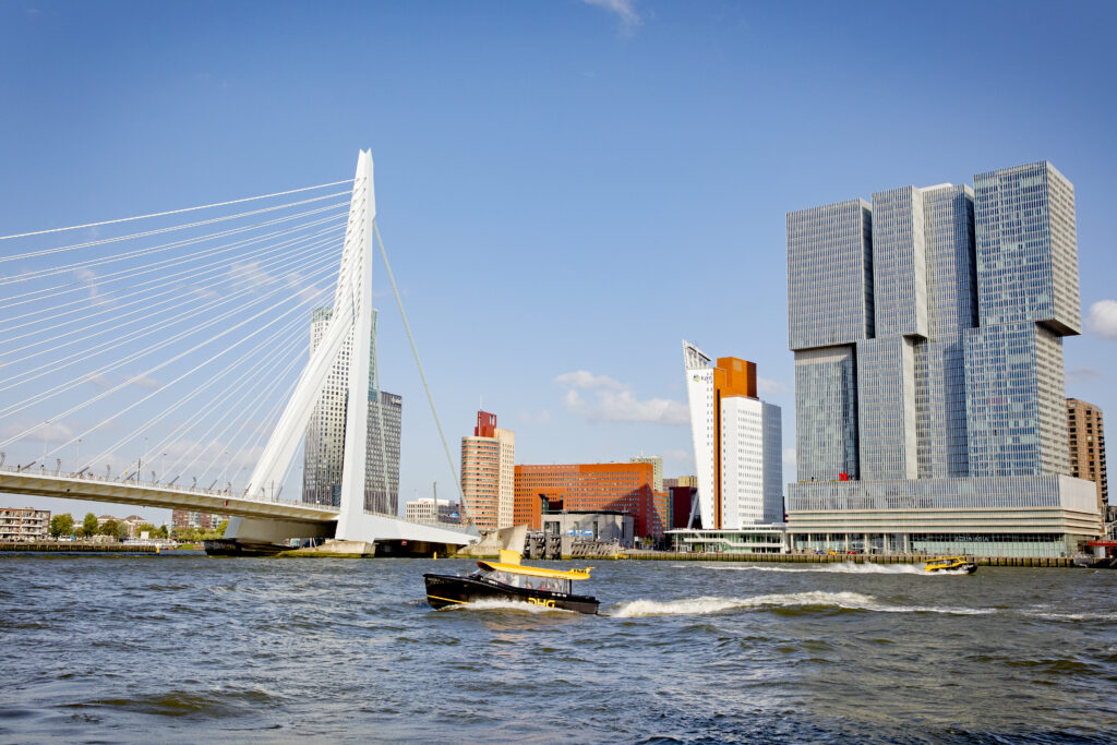 Watertaxi vaart voorbij de Kop van Zuid.