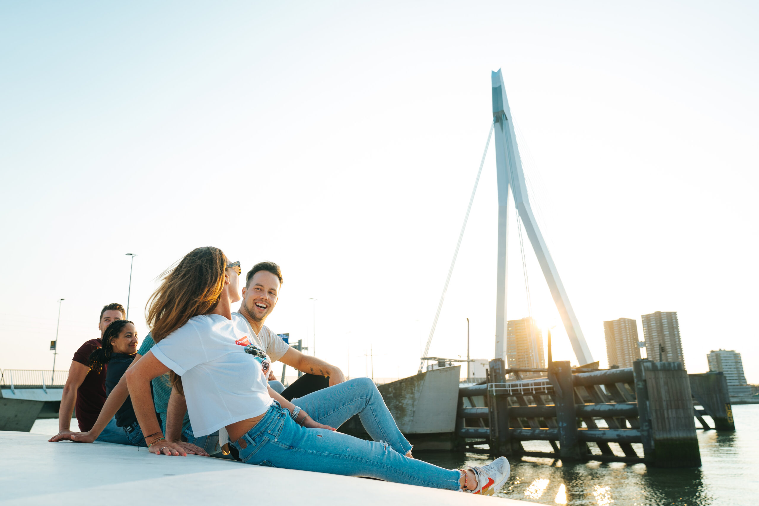 Vrienden chillen bij de Erasmusbrug.