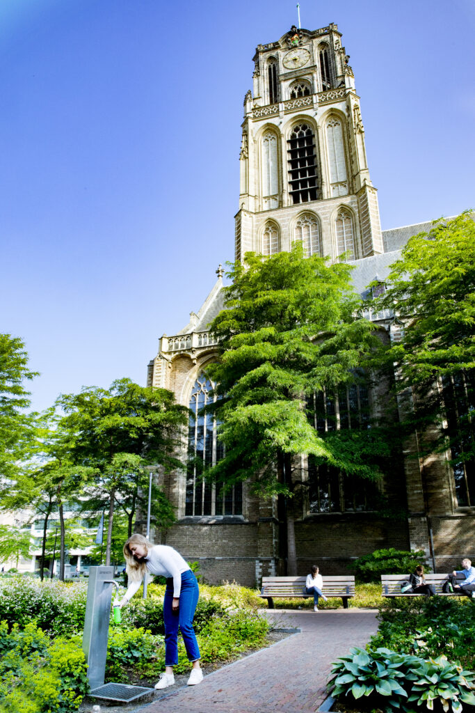 Vrouw bij drinkwaterpunt voor de Laurenskerk.