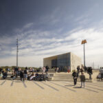 Toeristen genieten van de zon en van het uitzicht bij metrohalte Hoek van Holland Strand