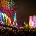 Nationale vuurwerk show in Rotterdam met een kleurrijk beeld van de Erasmusbrug en kop van zuid met vuurwerk.