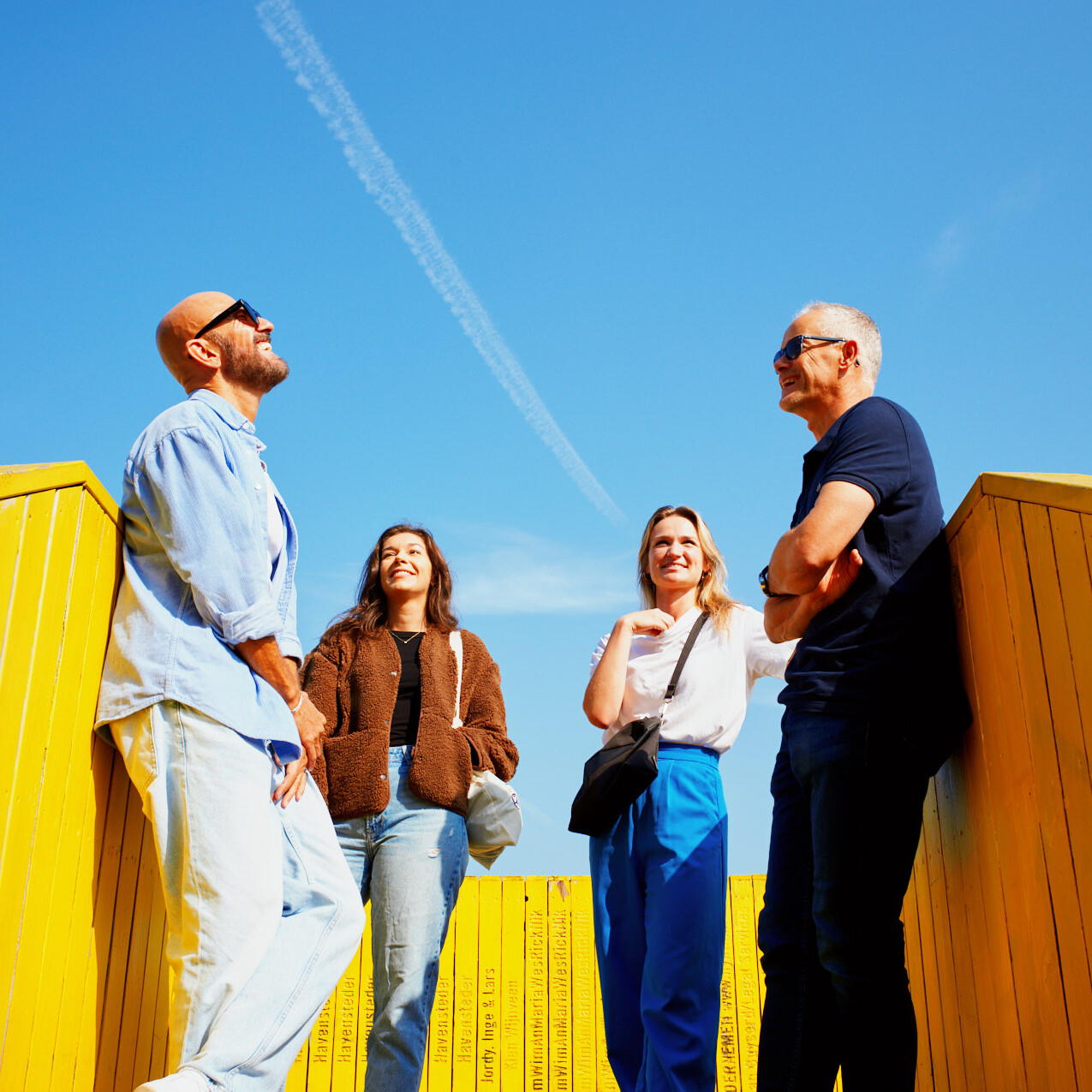 Rotterdammers op de luchtsingel die moeten lachten om elkaar in het zonnetje.