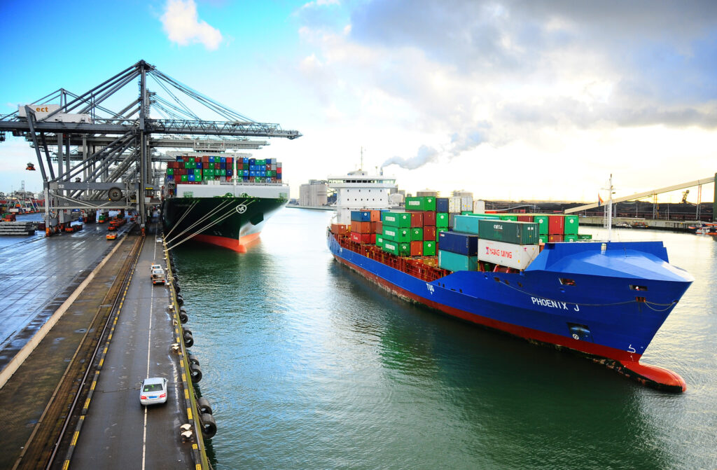 Een containerschip vaart weg van de kade in de haven van Rotterdam.