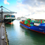 Containerschip vaart weg van de kade in de haven van Rotterdam