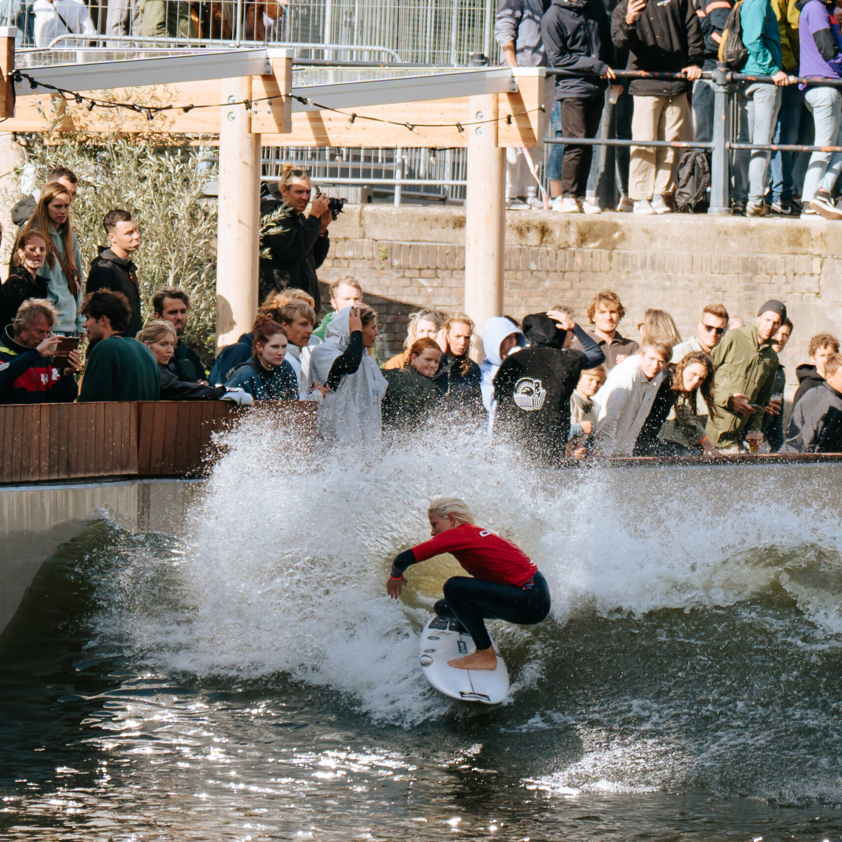 Surfer bij Rif010 die op een golf surft met heel veel publiek wat kijkt.